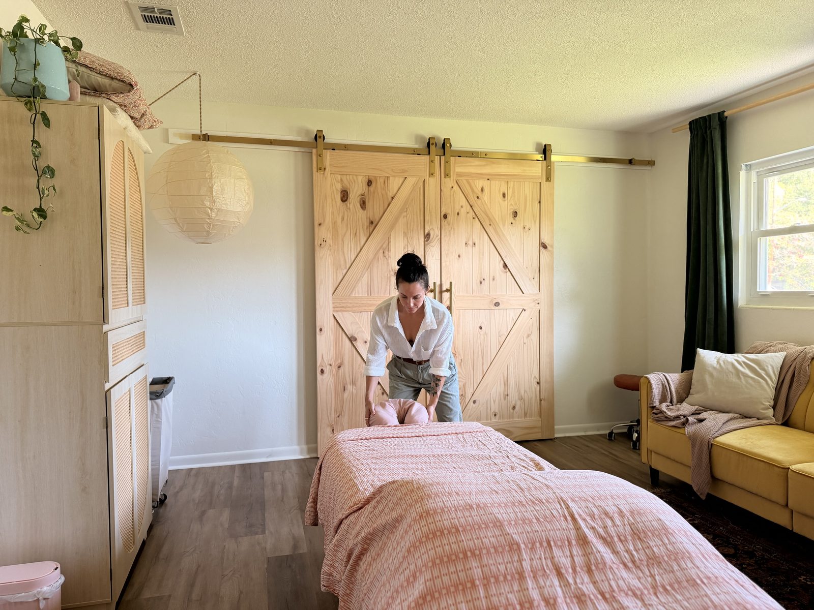 Kaleigh Eadens working at the head of the massage table in her treatment room