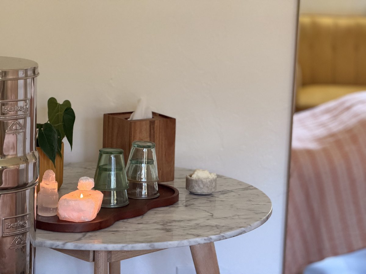 Marble side table with a salt lamp, selenite, glasses and tissues